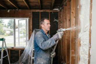 Homme en tenue de travail appliquant de l'isolation intérieure