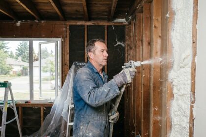 Homme en tenue de travail appliquant de l'isolation intérieure